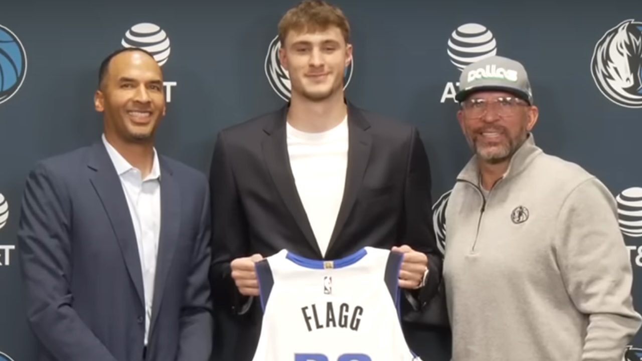 cooper flagg stands with his dallas mavericks jersey at a press conference